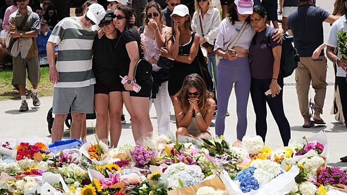 Cientos de personas se reúnen para depositar flores en el lugar del tiroteo mortal en Bondi Beach